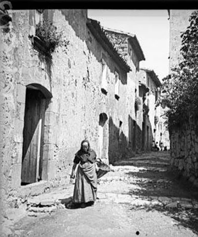 Una dona camina per un carrer de terra de Viladrau, 1916